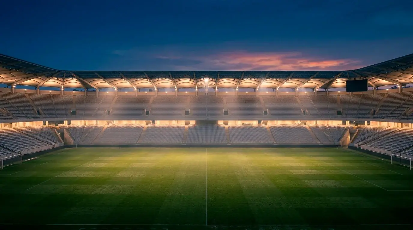 Stadiontribüne im Dämmerlicht mit grünem Rasen und Flutlicht in einem WM-Spiel